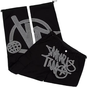 Svarta byxor med grafiskt tryck från minus two  - Coola svarta byxor med stort grafiskt tryck i silvriga stenar. Byxorna har en loose passform och dragsko vid bensluten för justerbar stil. Perfekta för en avslappnad och trendig look. Priset går att diskuteras. Köpta på minus two.