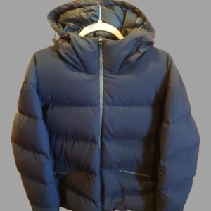 Laminar Stretch Down Parka - Säljer Laminar Stretch Down Parka i navy, storlek L. Nypris ca 11 000 kr. Denna stiliga och funktionella parkas är både varm och lätt, perfekt för kalla dagar. Med sin stretchiga passform och snygga design är den idealisk för både stadsliv och friluftsliv. Används sparsamt och i utmärkt skick. Kontakta mig för mer information eller bilder! Den är tillverkad med Gore-Tex-material vilket gör den vattentålig och vindtät, perfekt för alla väderförhållanden.