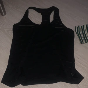  linnetopp från SOC - Säljer en röd och svart linnetopp från SOC med teknisk Airflow-funktion som håller kroppen torr och bekväm. Perfekt för träning med sin lätta och luftiga design.