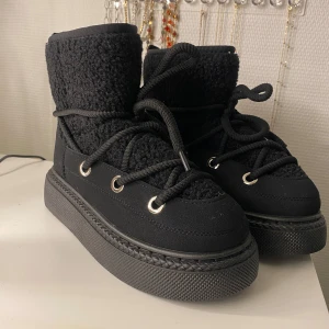Svarta moonboots med snörning - Snygga svarta moonboots med snörning och en robust sula. De har en stickad övre del som ger extra värme och stil. Perfekta för kyligare dagar. Säljer då jag råka klicka hem 2 par… Jättesköna och varma!! ✨✨