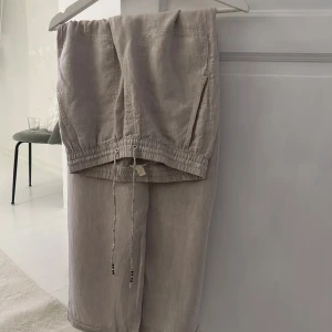 Beige linnebyxor med snörning - Säljer ett par bekväma beige linnebyxor med elastisk midja och snörning. Byxorna har en loose passform och är perfekta för en avslappnad stil. De har varit insydda så därav lite märken från de, men syns inte när man har dom på, skriv för frågor💌 nypris va 800kr🧚🏼‍♀️