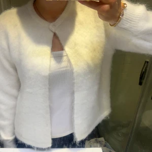 Vit fluffig kofta  - Mysig vit stickad kofta från Bik bok i mohair. Så så snygg kofta. Fick i julklapp och den är helt oanvänd och har lappen kvar. Nypris: 699