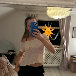 Beige croppad t-shirt med ficka - Säljer en beige croppad t-shirt med en liten ficka på bröstet. T-shirten har en avslappnad passform och korta ärmar, perfekt för en ledig stil.