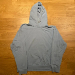 Ljusblå hoodie från 157 - Säljer en ljusblå hoodie från 157 i storlek M. Den har en klassisk design med huva och dragsko, samt ribbade muddar vid ärmslut och nederkant. Perfekt för en avslappnad stil.
