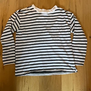 Randig långärmad tröja från lager 157 - Säljer en klassisk svartvit randig tröja från lager 157. Tröjan är tillverkad i 100% bomull.