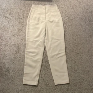 Beige kostymbyxor - Snygga beige kostymbyxor med hög midja och dragkedja. Perfekta för en stilren look.