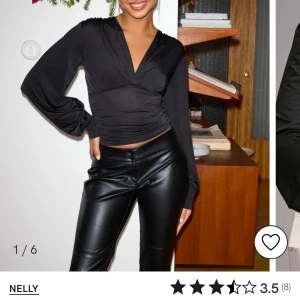 Svart plunge LS topp från Nelly - Snygg svart topp från Nelly med långa ärmar och v-ringad design. Toppen har en åtsittande passform med rynkade detaljer i midjan som ger en smickrande siluett. Aldrig använd 