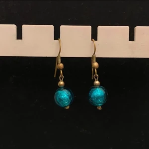 Blå örhängen med pärlor - Snygga örhängen med blå pärlor som hänger från en enkel krok. Perfekta för att ge en färgklick till din outfit. De har en elegant och tidlös design.