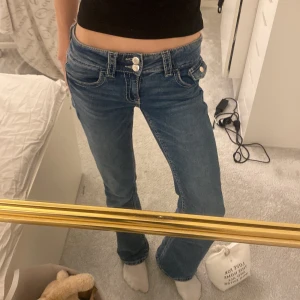 Blå jeans med låg midja - Snygga blå jeans med låg midja och bootcut-stil. De har en klassisk femficksdesign och dubbla knappar i midjan. Perfekta för en avslappnad look. Från Gina Young i tall💗