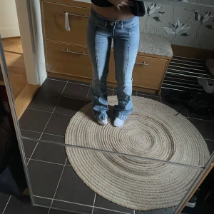 Lågmidjade Blå bootcut jeans - Snygga blå bootcut jeans med låg midja. Perfekta för en avslappnad stil. De har en klassisk femficksdesign och en bekväm passform. Säljer då de är för långa för mig🥰 De är lite slitna längst ner i benen!!