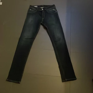 Mörkblåa jeans från replay - Snygga mörkblåa jeans från replay i wallys super slim passform. De har en klassisk femficksdesign med dragkedja och knapp framtill. Perfekta för en stilren look. Aldrig använda. 