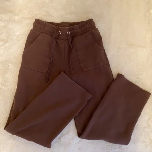 Bruna mjukisbyxor Lager 157 - Säljer ett par bruna mjukisbyxor med elastisk midja och snörning. Byxorna har fickor både fram och bak, vilket gör dem praktiska och bekväma. Perfekta för en avslappnad stil. Från lager 157 