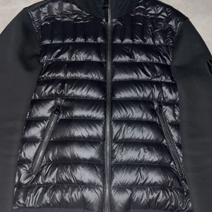 Svart jacka från Mackage - Säljer en stilren svart jacka från Mackage. Jackan har en quiltad framsida med dragkedja och långa ärmar. Perfekt för kyligare dagar med sin snygga och funktionella design.