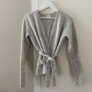 Kofta med knytning i midjan  - Ljusgrå kofta med knytning i midjan. Från Vila, jättefint skick 
