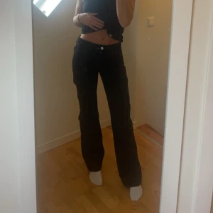 Svarta byxor med knappar - Mid waist svarta jeans med cargodetaljer. Rak passform, mycket bekväma.