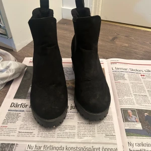 Svarta boots med klack - Snygga svarta boots i mocka med klack och grov sula. Perfekta för en stilren look. Passar för storlek 38-39.