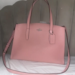 Coach Väska Charlie Carryall rosa - Otroligt fin rosa färg! En toppen-väska för vardag eller shopping. Äkta coach, du får labels med väskan. Föreslå pris 💖🎀