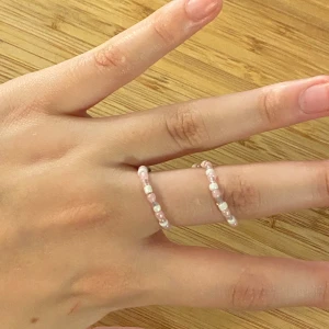 Rosa ring, pärlor, justerbar - Egentillverkad ring av pärlor och ståltråd🩷ringen går att justera storlek och form på. Om man sträcker ut ringen helt är den ca 11 cm. Går att beställa i valfri färg/färger💅🏼