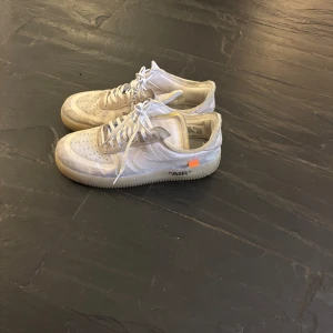 Sneakers i vitt med textdetaljer - Snygga vita sneakers med textdetaljer på sidan och en genomskinlig sula. Skorna har även en liten orange detalj vid hälen.