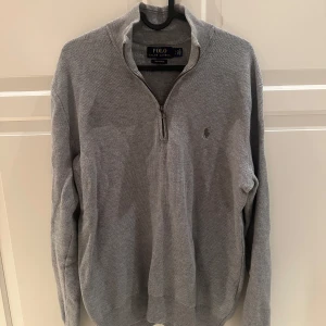 Grå tröja med dragkedja från Polo Ralph Lauren - Säljer en grå tröja från Polo Ralph Lauren. Tröjan har en halv dragkedja och är i storlek small. Bra skick.