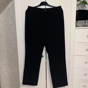 Svarta byxor från Object - Snygga svarta byxor från Object med en klassisk design. De har en knapp framtill och en rak passform som ger en stilren look. Perfekta för en elegant och tidlös stil.