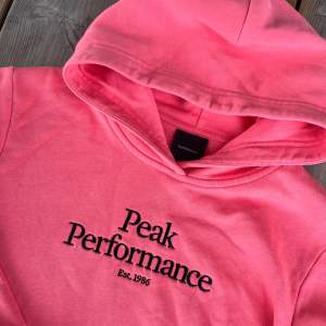 Säljer en snygg och bekväm korallrosa hoodie från Peak Performance. Som ny! 