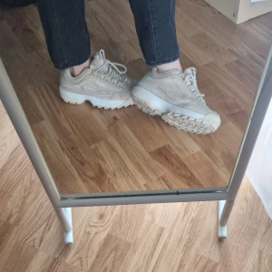 Beige sneakers från Fila - Bekväma beige sneakers från FILA. Modell disruptor S Low. Aningen små i storleken. De är i mocka och har en chunky sula. Skorna är i bra skick men har små tygbollar på insidan som endast är kosmetiskt (ses på bild 4)