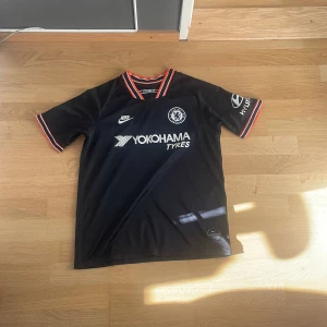 Chelsea FC tröja 19/20 - Sjukt fet tröja för alla chelsea fans. Säljer då den är för liten för mig. Storlek xxs. 100% äkta.  Den är använd ganska mycket men fortfarande i bra skick. Den enda defekten är i kragen då den har blivit lite urtvättad. Priset är inte hugget i sten.