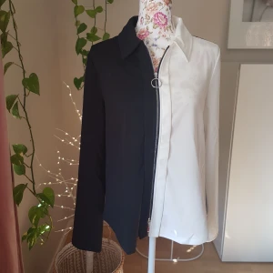 Svart/vit färgblock skjorta/overshirt - Aldrig använd. Tjockare polyester, stängs med dragkedja. (Cruella de Vil-vibbar ingår! $) ~ STOR rensning i min shop ~ Välj 5 för 100kr oavsett pris, skicka medd/lämna som prisförslag (gäller där det står) ~
