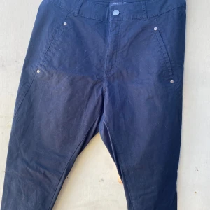 Svarta byxor från KappAhl - Säljer ett par svarta byxor från KappAhl i storlek 42. Byxorna har en klassisk design med fickor både fram och bak. Perfekta för vardagsbruk och kan enkelt matchas med olika toppar. De är i bra skick och redo för en ny ägare!