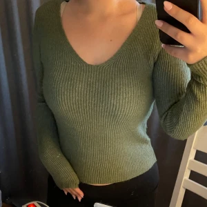 Stickad långärmad tröja  - Säljer denna jättefina mörkgröna stickade tröjan som är i bra skick och som har använts få gånger. 