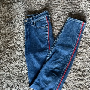 Lee jeans - Snygga Lee jeans med röda revärer, i väldigt fint skick då de är sparsamt använda.  Stl W26 L31