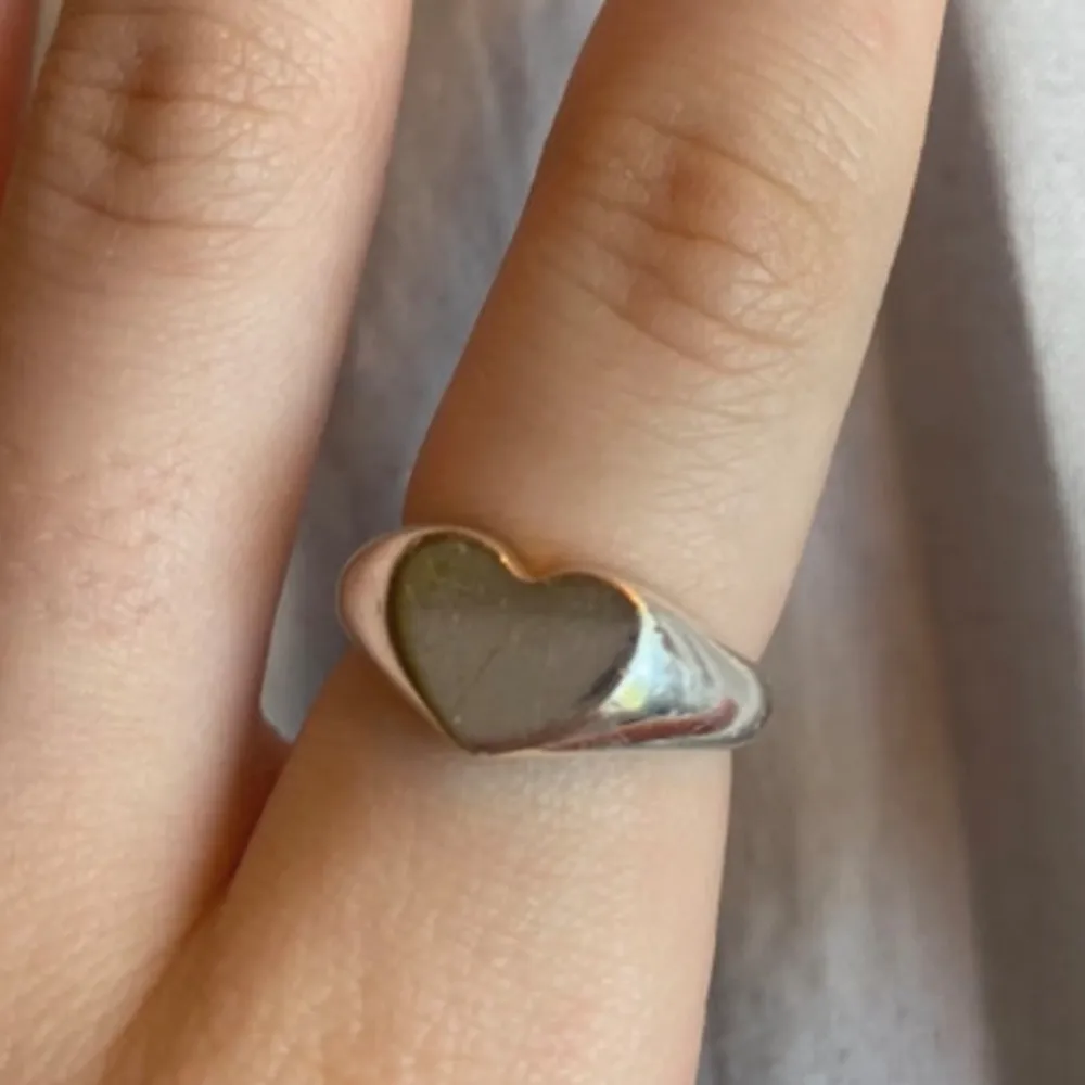 Säljer en superfin silverring med ett hjärta på toppen. Den är stilren och perfekt för att ge en subtil touch av kärlek till din outfit. Passar både till vardags och fest!. Accessoarer.