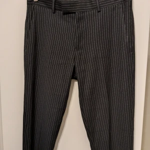 Randiga kostymbyxor från River Island - Säljer ett par stiliga kostymbyxor från River Island. De är svarta med tunna vita ränder, vilket ger en klassisk look. Sjukt snygga men inte riktigt min stil och kommer därför inte till användning här.