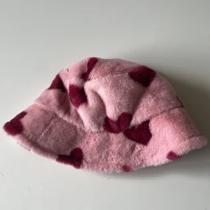 Fluffig hatt från monki - Rosa hatt från monki. Materialet är så skönt. Impulsköpet den, kommoden på att mitt huvud var för stort(har stl 57) hatten är i stl 54. Den är alltså som ny, helt oanvänd💔