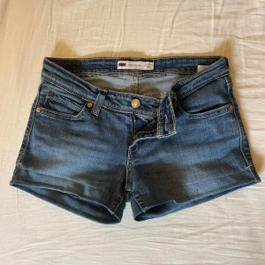 Levi’s jeans shorts - Ljusblåa tighta jeans shorts från Levis!! Storlek W26 (ca xs ) midjemått 75cm och mått tvärsöver midjan 35cm