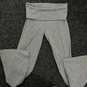 Grå mjukisbyxor från Gina Tricot - Säljer mina superbekväma gråa yoga pants från Gina Tricot. Man kan ha de både högmidjade och lågmidjade beroende på hur mycket man viker ner dem och har en loose passform med vida ben. Perfekta för en chill dag hemma eller en avslappnad dag ute. Materialet är mjukt och stretchigt, vilket gör dem extra sköna att ha på sig. Köp direkt eller ge prisförslag 💛