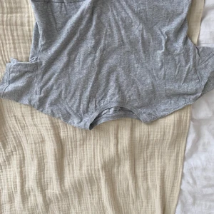 Grå tshirt - T-shirt grå från ellos som är lite croppad som kan användas över ett linne eller annat, den är gammal men inte mycket använd