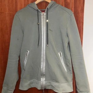 Olivgrön limitato zip hoodie  - En olivgrön limitato zip hoodie med få små defekter, strl M passar bra till S. Kvitto finns tyvärr ej då den är köpt för ett bra tag sen, men har ej fått så mycket användning för den under det senaste året. Pris kan diskuteras under en snabb affär.