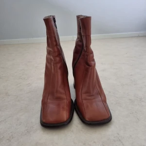Bruna högkladdade boots  - Storlek 37, ca 5 cm hög klack Dem är köpta second hand så känner inte till märket. Märket ser ni på sista bilden. Fråga om ni undrar över något 