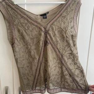 Beige ärmlös topp från H&M - jättefin topp från H&M köpt secondhand. den passade tyvärr inte mig men den är jättefin på! 
