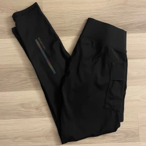 Träningsthights - Så fina tränings tights från newbody med en ficka och regnbågsfärgad detalj på benen. Aldrig använda & helt nytt skick🤍