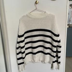 Ginatricot Stickad tröja - En grovstickad tröja från Ginatricot med slits i ärmarna. Stor i storleken.