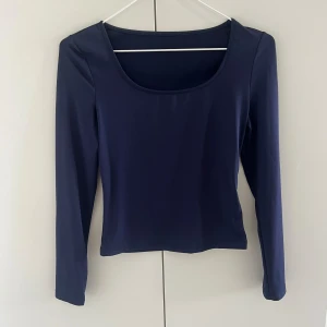 Tajt långärmad tröja - Tajt långärmad tröja i marinblått.  Knappt använd och har inga skador.  Man kan välja att ha den på båda hållen. Antingen lite djupare urringning fram eller bak. Själv föredrar jag att ha den djupare i ryggen. 