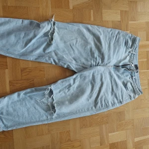 Jeans - Ljusblåa jeans, raka i passform med hål i knäna.