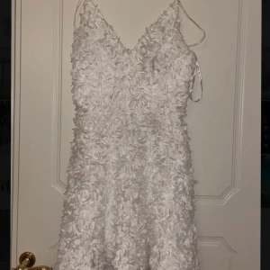 Studentklänning - Vit blommig klänning perfekt till studenten! Köpt på sellpy men fick ingen användning för den då jag köpte en annan. Storlek S 