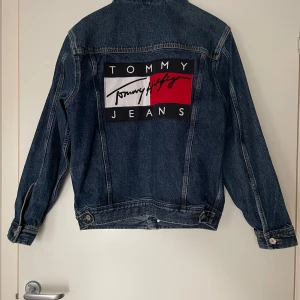 Jeansjacka Tommy Hilfiger - Jeansjacka från Tommy Hilfiger. Helt ny i en vintagestil. Använd 1 gång.  Storlek XS herr, använd som en oversized S för dam.