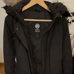 Canada goose  - Säljer min svarta canada goose jacka(tjej modell)  , storlek xs, använd 3 vintrar men är i riktigt bra skick . Man kan dessutom spänna hur mycket man vill där bak. 
