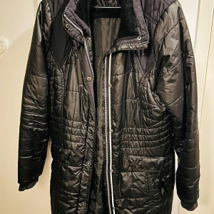 Svart quiltad jacka från Cecil - Säljer en svart quiltad jacka från Cecil i storlek L. Jackan har en mysig fuskpälsfoder vid kragen och stängs med dragkedja och knappar. Perfekt för kyliga höst- och vinterdagar. Den har långa ärmar och en stilren design som passar till det mesta. 🖤