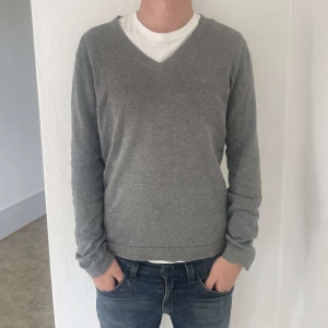 V-ringad stickad tröja från Bläck - Säljer en V-ringad stickad tröja från Bläck i storlek M. Inga större defekter förutom att sömmarna gått upp på en liten del av nacken (bild 4) Personen på bilden är 193 lång. Hör av er vid eventuella frågor.